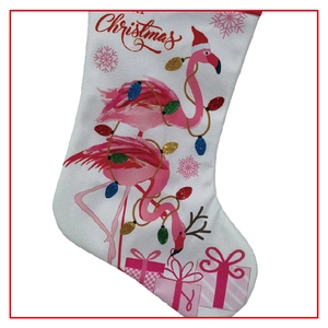 Detail of white fabric Christmas stocking with flamingo print and festive ornaments