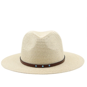 Dettaglio ravvicinato del cappello Fedora beige in lino con fascia in pelle e borchie