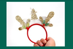 Detailed view of a festive Christmas headband with golden sequin antlers and a mini Santa hat