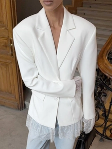 Detail of white lace patchwork on cuffs and hem of a slim fit women's blazer