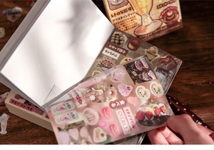 Macro detail of vintage-style stationery stickers and a person flipping through the notebook