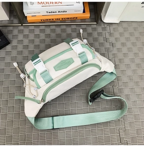 Top-down detail of white and mint green nylon crossbody bag with buckle and zipper