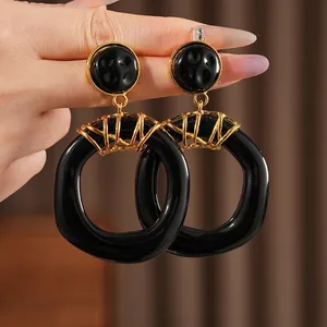 Vintage geometric black resin hoop earrings with gold metal wrap details for women
