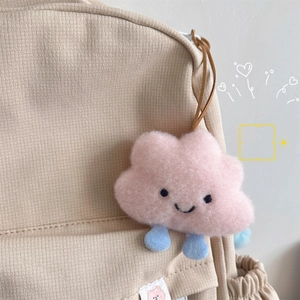 Cute pink cloud plush pendant with blue feet on a canvas backpack strap