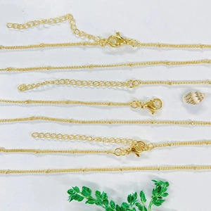 Detail of gold-plated satellite chains with small beads, lobster clasp and extension