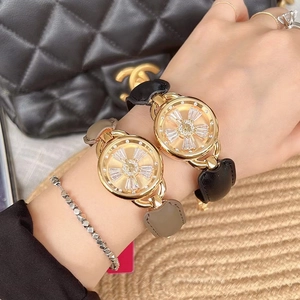 Detail of luxury gold watches with black and grey leather straps and diamond flower dial