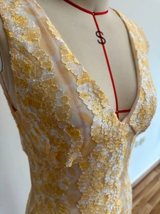 Detail of yellow and white floral lace texture on V-neck backless bodycon dress