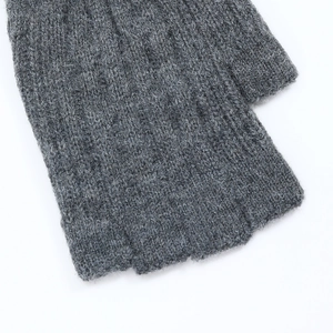 Macro detail of grey cable knit fingerless gloves showing thumb hole and ribbed texture
