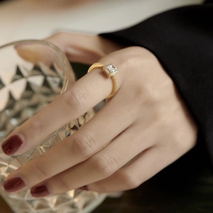 Elegant gold square zircon ring with sparkling side stones worn on a hand