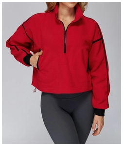 Detail of red fleece jacket with black piping, half-zip collar and adjustable hem cord