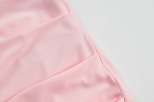 Gros plan du tissu en maille rose avec tissage sergé et coutures soignées de la robe