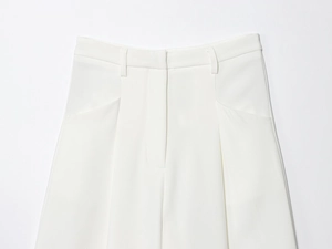 Détail du pantalon blanc à taille haute avec passants et finitions de couture précises