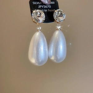 Detailed view of silver 925 drop pearl earrings with faceted round cubic zirconia stones