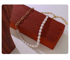 Detail of 18K gold-plated link chain and freshwater pearls on a wooden block