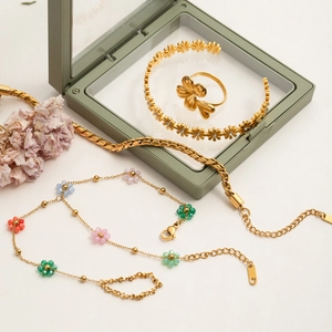 Detail of gold floral stackable rings and bracelet with crystal accents on a display box