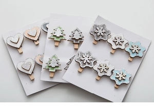 Close-up of wooden Christmas clips with glitter heart, snowflake and tree designs