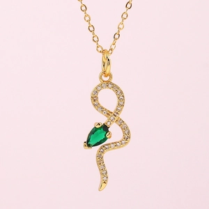 Détail du collier pendentif serpent doré orné de cristaux et d'une gemme verte en goutte