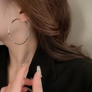Polished silver large hoop earrings shown on a model for a minimalist fashion look