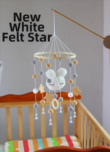 Detail of wooden baby mobile with plush bunny head, felt stars, and decorative bells