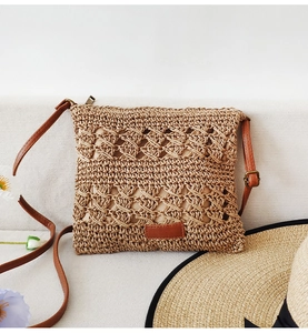 Close-up of hollow paper rope woven beach bag with premium brown leather strap