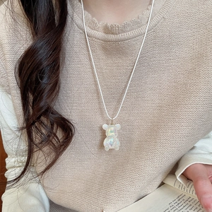Pearlescent white resin bear pendant necklace with cord chain shown on a model