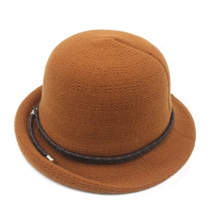 Detail of caramel brown knitted bucket hat showing weave texture and cord with metal tips