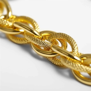 Close-up of gold layered aluminum chain necklace with polished and matte textured finish