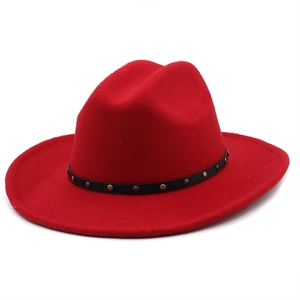 Detail of red wool felt cowboy hat with black leather band and metal rivet studs