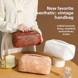 Detailed close-up of vintage embossed floral patterns on stylish PU leather cosmetic bags