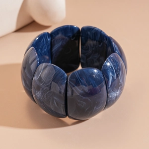 Detailed close-up of dark blue marble pattern acrylic wide stretch bracelet