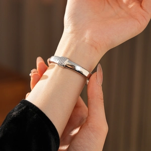Gros plan d'un bracelet jonc en acier titane argenté serti de pierres sur un poignet