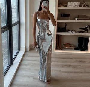 Detail of silver sequin evening dress with cross back straps and shimmering texture