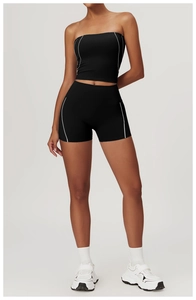 Détail du short de yoga noir à taille haute et du haut de sport à rayures blanches