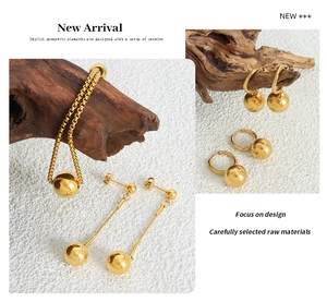 Polished gold-plated steel jewelry set featuring spherical pendant necklace and hoop earrings
