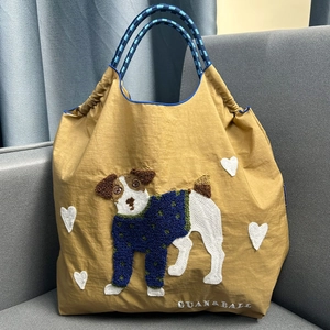 Detail of khaki nylon tote bag featuring cute dog embroidery and heart patterns
