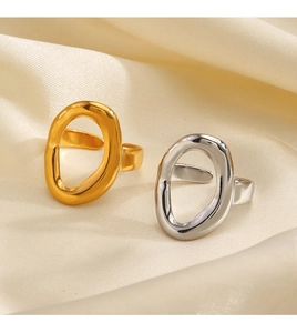 Minimalist irregular oval rings in gold and silver finish on silk fabric texture