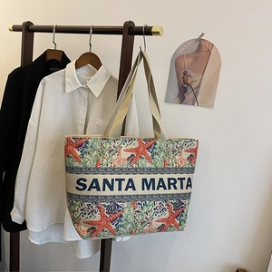 Detailed view of canvas tote with red starfish pattern and Santa Marta embroidery