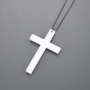 Detail of a white matte wooden cross pendant with dark grey industrial metal bead chain