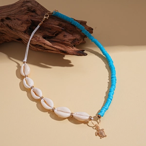 Detail of beaded necklace with sea turtle pendant on driftwood for beach vibes