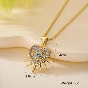 Macro view of gold heart pendant with evil eye and zircon details and product size