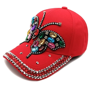 Detailed view of large colorful butterfly jewel embellishment on red baseball cap