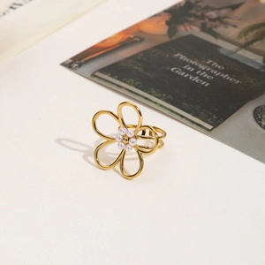 Gros plan détaillé d'une bague fleur plaquée or 18 carats avec perles sur fond crème