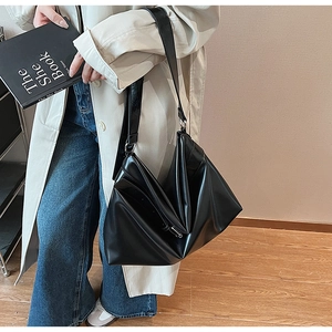 Détail du sac hobo noir minimaliste avec design géométrique plié et finition brillante