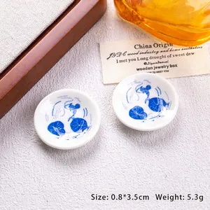 Close-up of miniature blue and white porcelain plates with traditional fish and lotus patterns