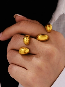 Macro shot of 18K gold plated teardrop open rings showcasing glossy polished texture