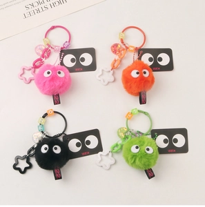 Detail of colorful fluffy plush ball keychains with cartoon eyes and star-shaped hooks