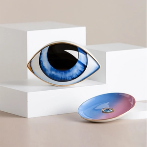 Detailed view of evil eye ceramic jewelry dish with gold trim and blue gradient finish