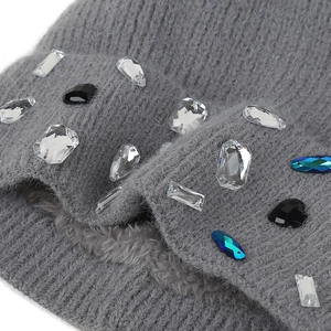Detail of grey knitted hat featuring warm faux fur lining and sparkling rhinestone accents