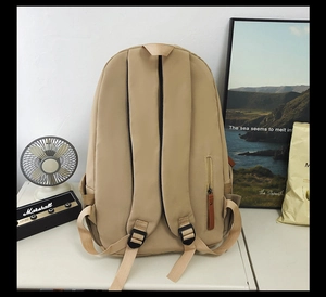 Detailed back view of khaki backpack showing anti-theft zipper and padded straps