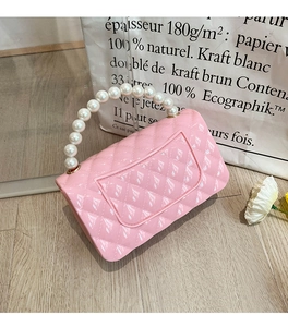 Detailed shot of pink jelly handbag with quilted texture and elegant pearl handle